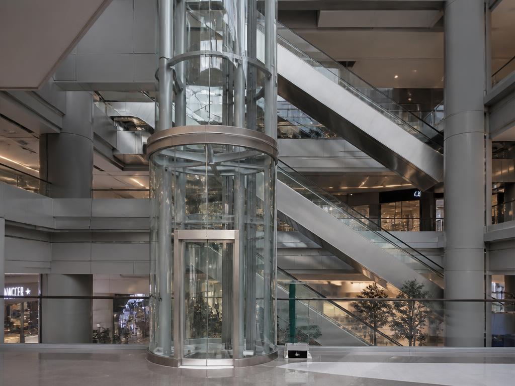 Panoramic glass elevator and escalators in a shopping mall atrium